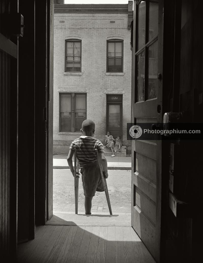 Young boy standing in the doorway of his home. Washington, D.C. 1942 