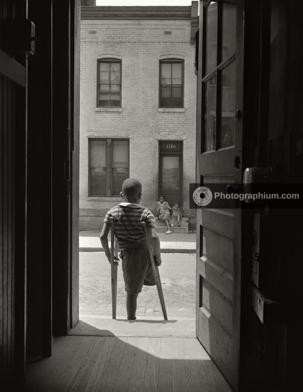 Young boy standing in the doorway of his home. Washington, D.C. June 1942