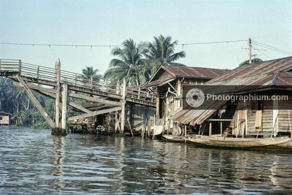 Riverside houses and a wooden bridge. Cambodia. 1976